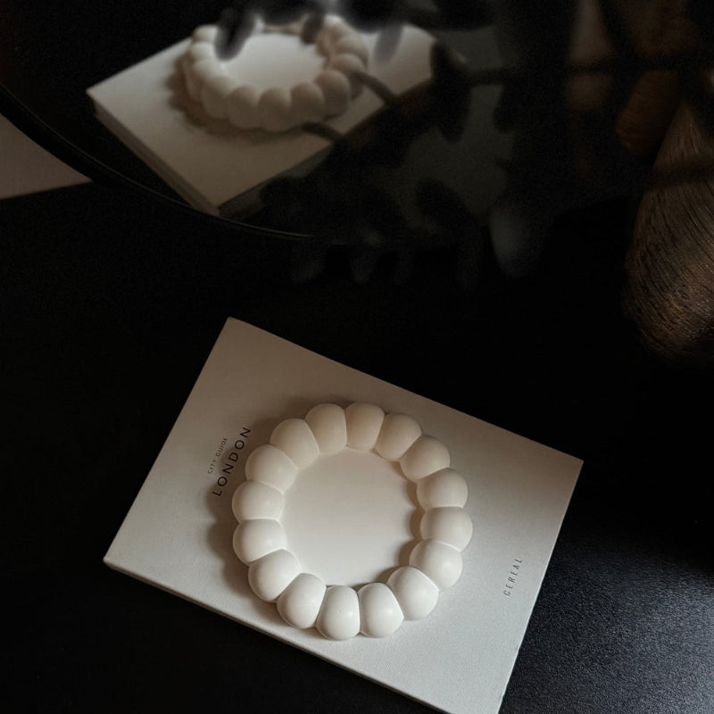 White stone Decor tray sat on a grey book, black background