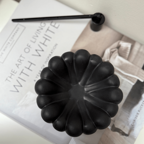 Black decorative bowl on a magazine with text