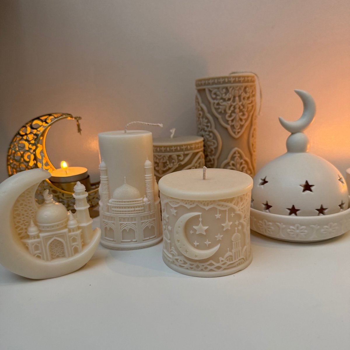 Decorative incense burner with a moon and star design on a white background with decorative Eid candles beside it