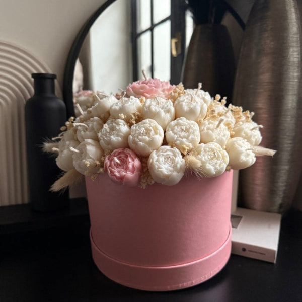 Pink box with white and pink flowers on a dark surface