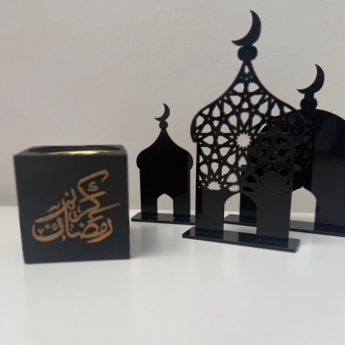 Decorative black metal Bakhoor burner with intricate designs on a white surface