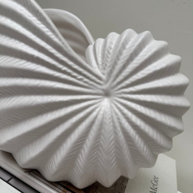 White decorative object with textured surface on a light gray background