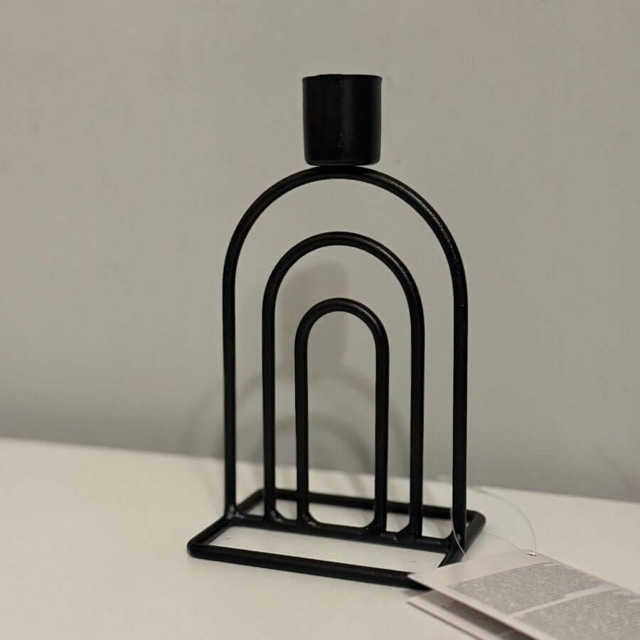 Contemporary Metal Arch Taper Candle Holder on a light surface with a neutral background