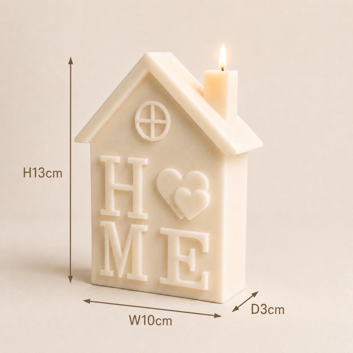 A house-shaped cream candle with a lit wick on top, featuring the word 'HOME' and a heart design on the front. Measurement arrows and labels indicating height 13cm, width 10cm, and depth 3cm are overlaid on the image.