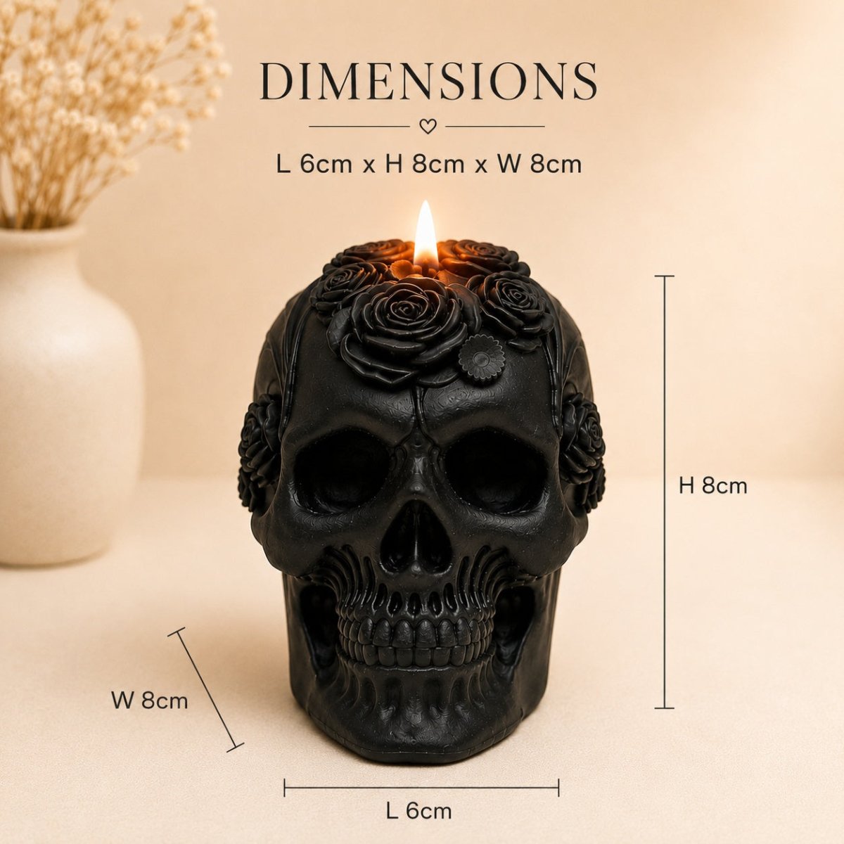 Black skull-shaped candle with a lit flame and rose details on top, shown with overlaid dimension labels reading L 6cm, H 8cm, and W 8cm on a beige background.