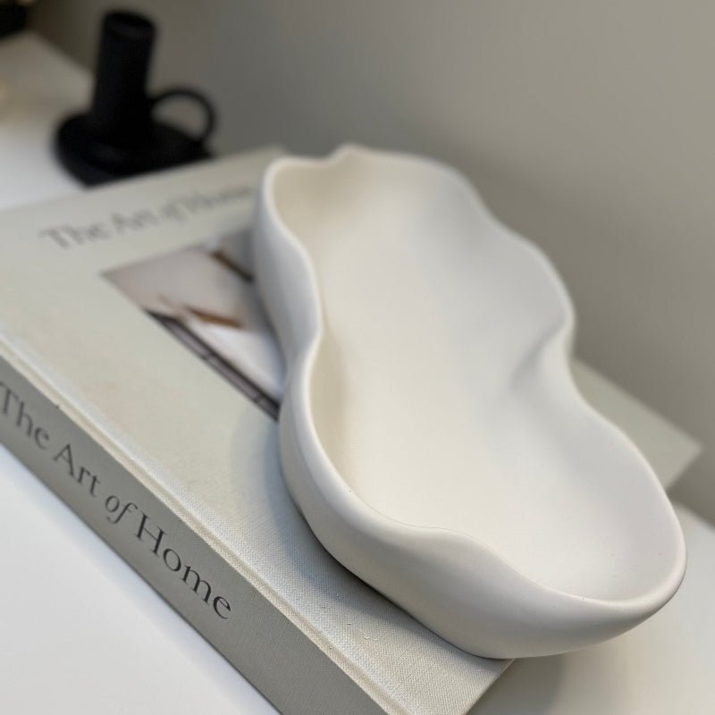 White ceramic dish on a book titled 'The Art of Home'