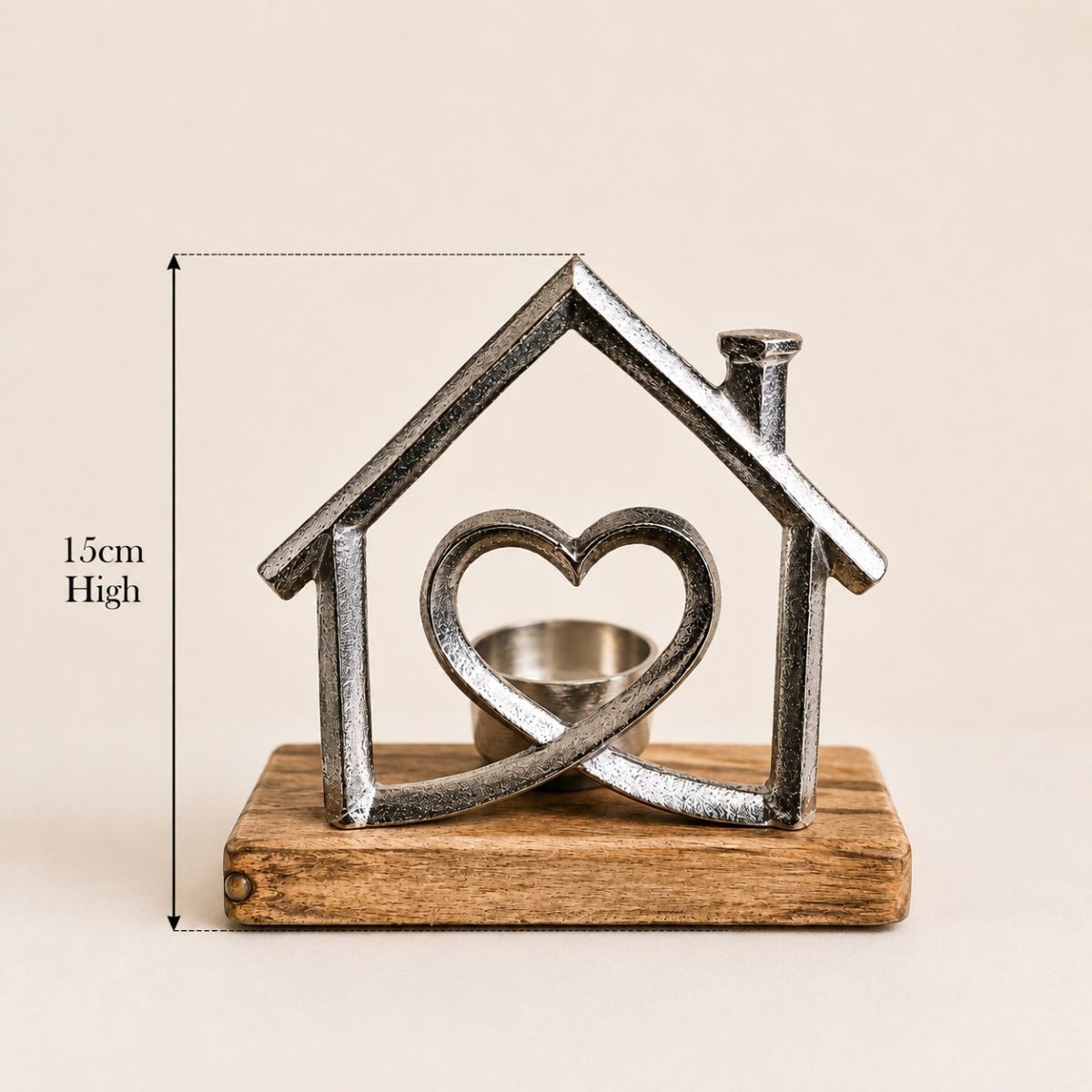 A small decorative house-shaped metal candle holder with a heart motif in the center and a wooden base, shown on a plain beige background with a height measurement annotation of 15cm.