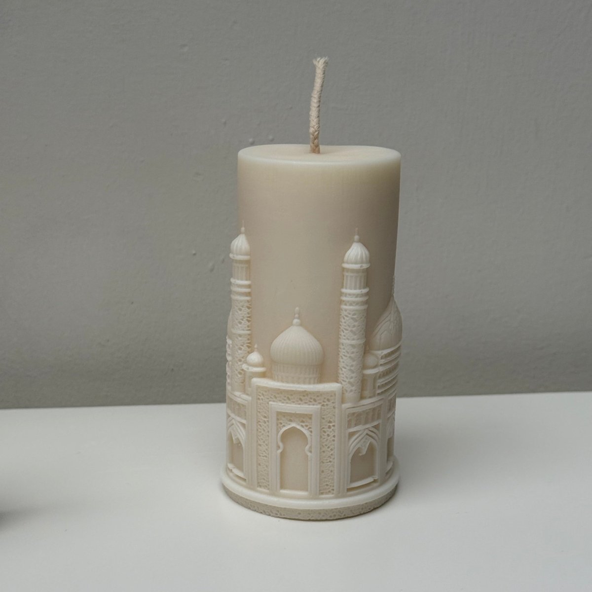 Decorative candle with intricate design on a gray background