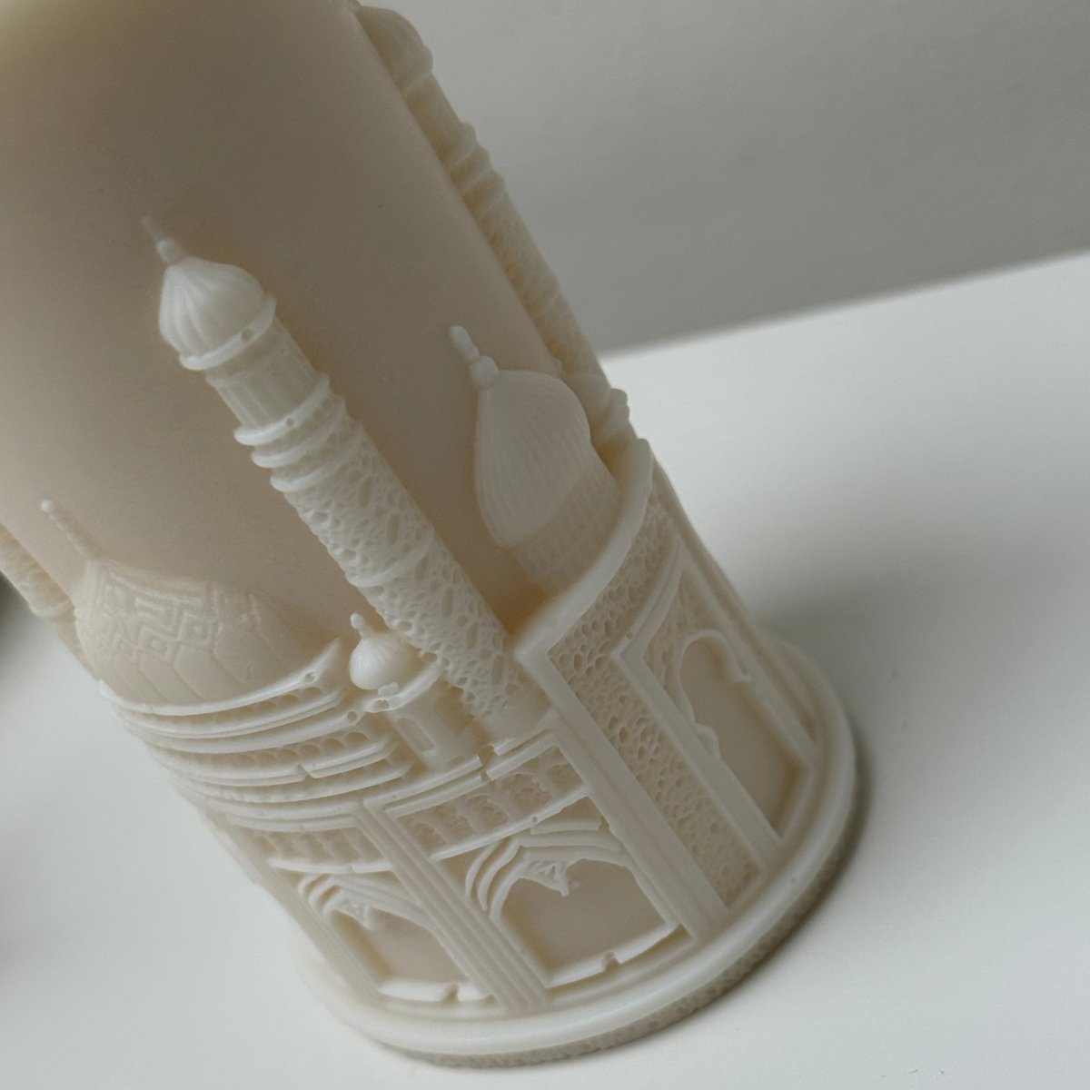 Close-up of a mosque pillar  candle with intricate patterns on a light gray background
