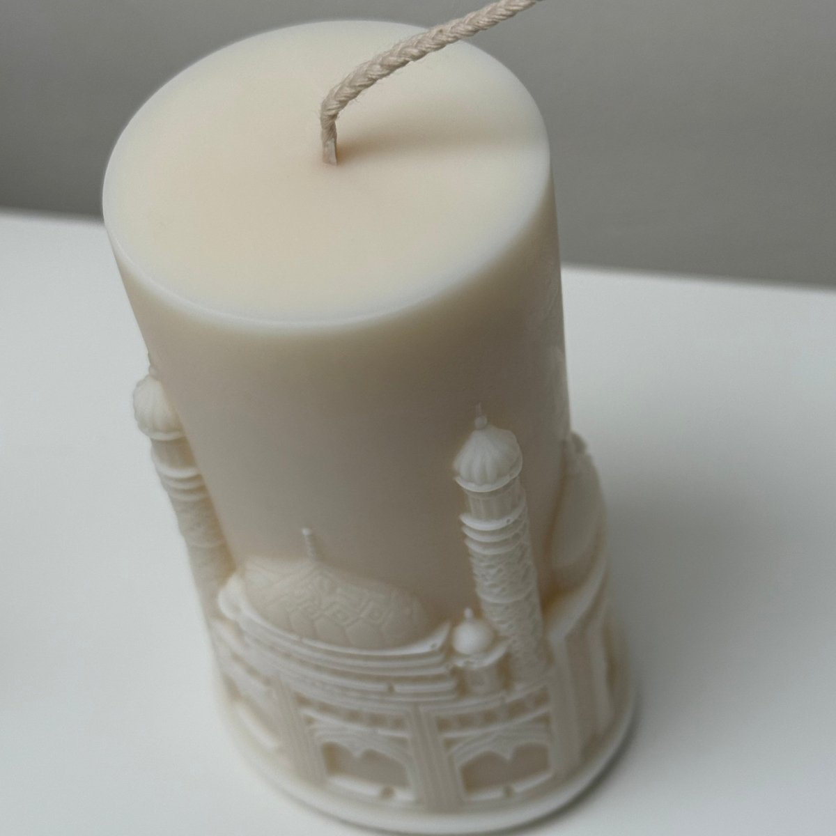 White candle with intricate design on a white background