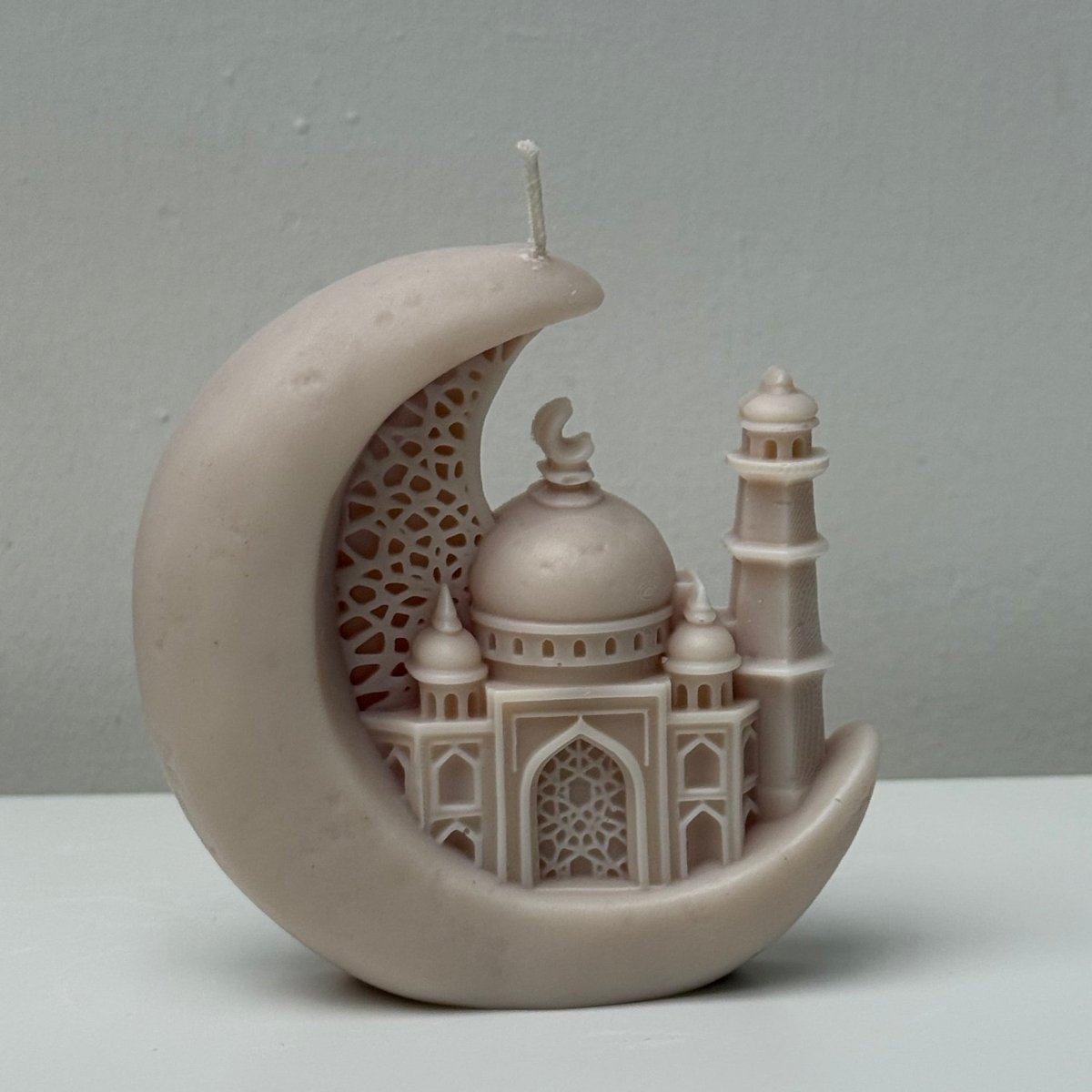 Decorative Candle resembling a mosque on a crescent moon against a gray background