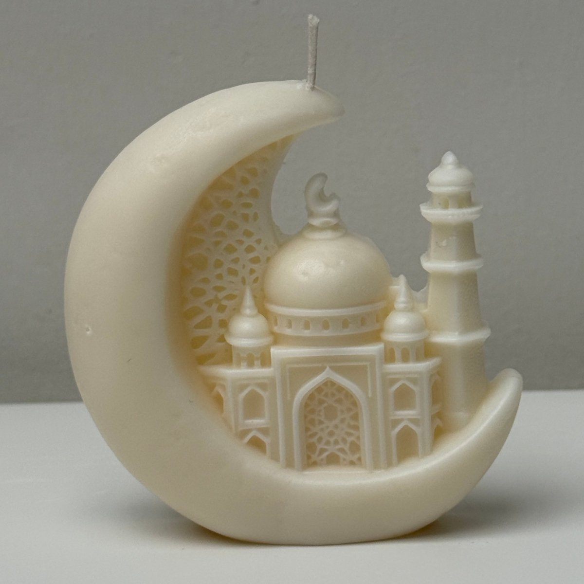 Decorative Candle resembling a mosque on a crescent moon against a gray background