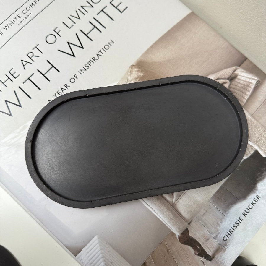 Black decorative tray on a magazine titled 'The Art of Living with White'.