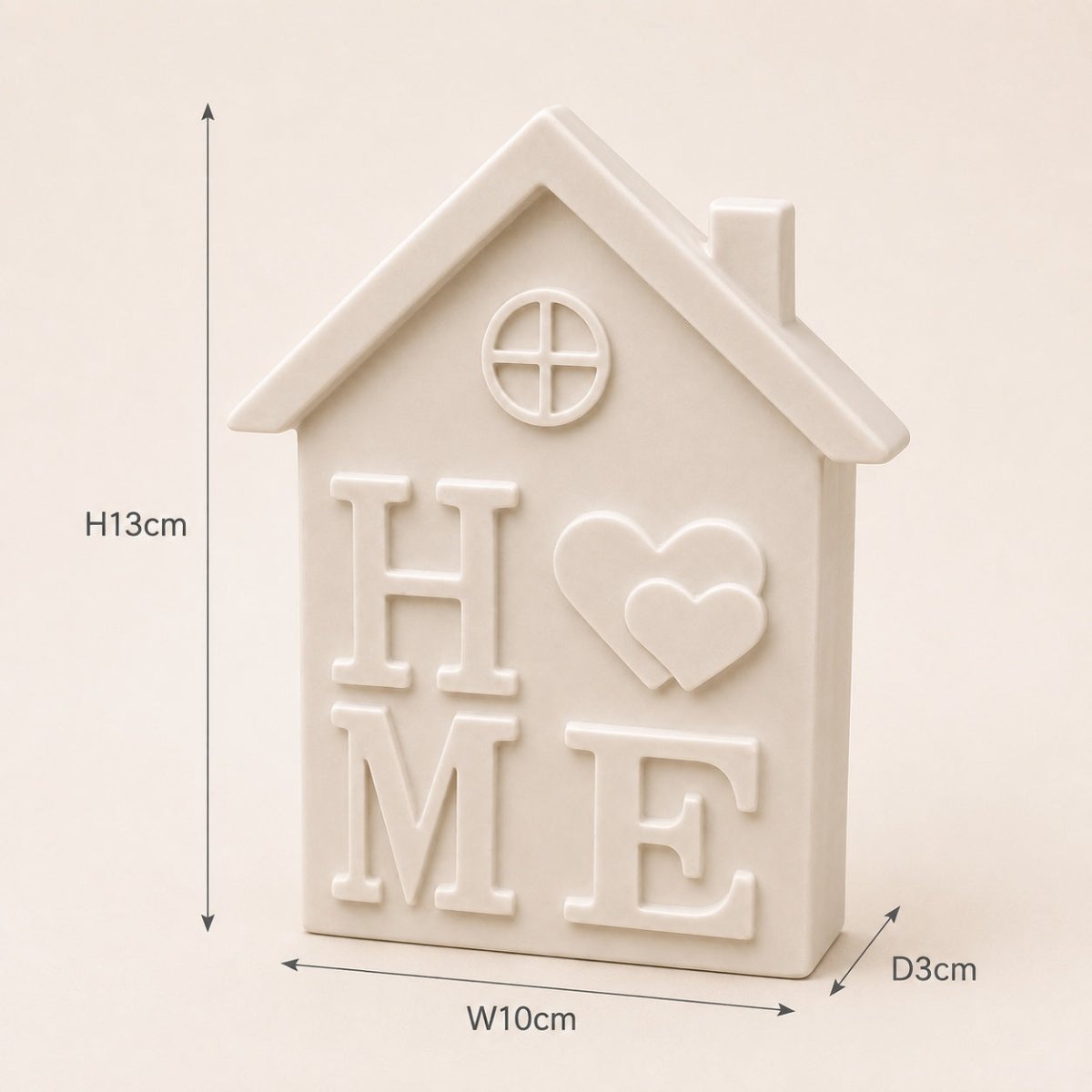 A house-shaped decorative piece with raised letters spelling HOME, a heart motif, and a small window, shown on a light beige background with dimension arrows and labels indicating height 13 cm, width 10 cm, and depth 3 cm.