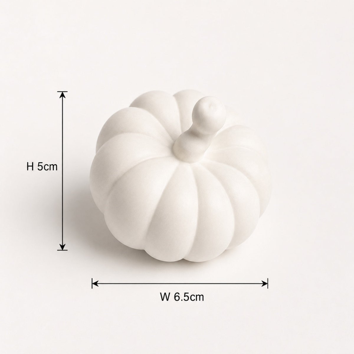 A small white decorative pumpkin figurine shown on a plain light background with dimension arrows and labels indicating height 5 cm and width 6.5 cm.