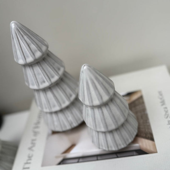 Decorative gray Christmas trees on a book with a blurred background