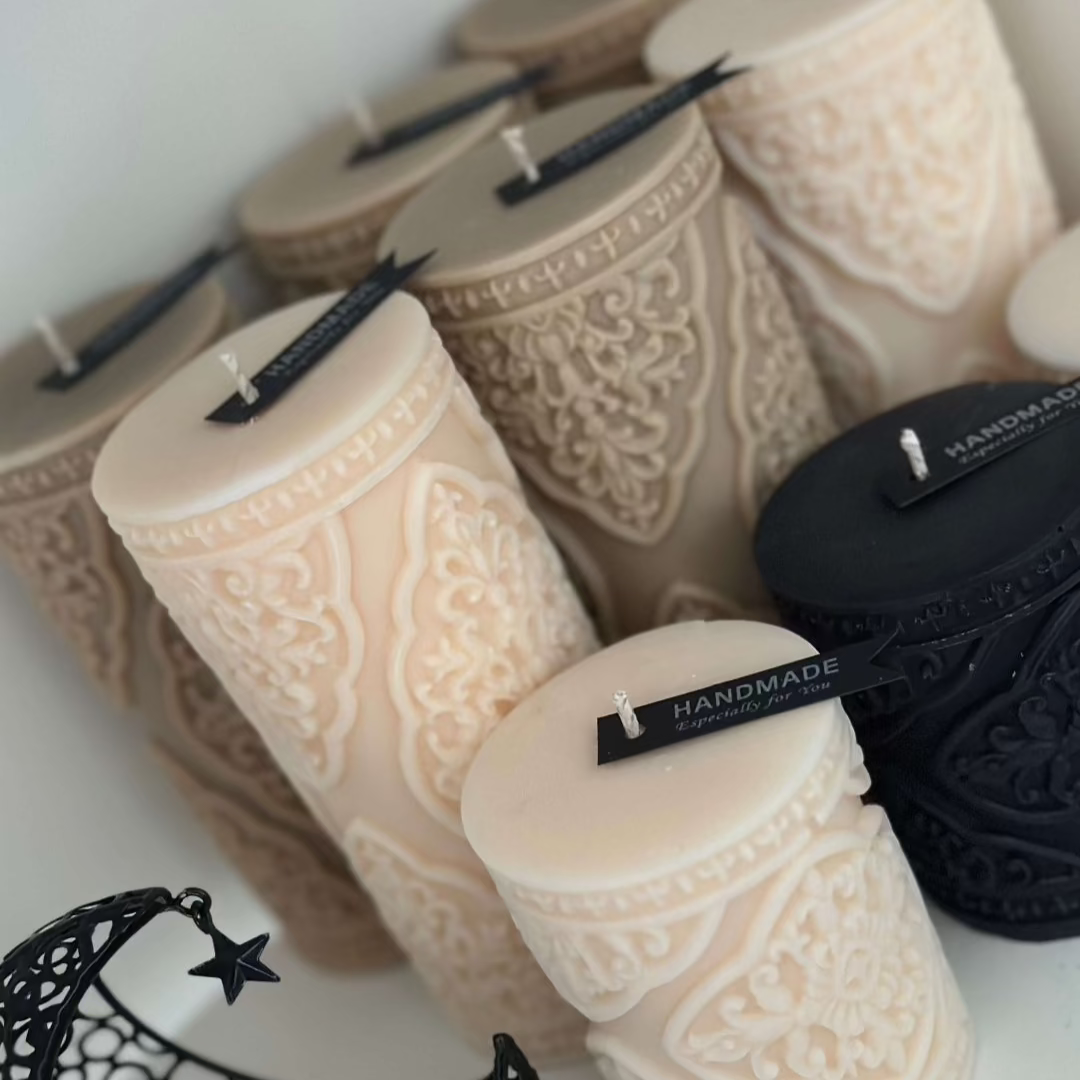  beige, cream and black intricately designed pillar candles 